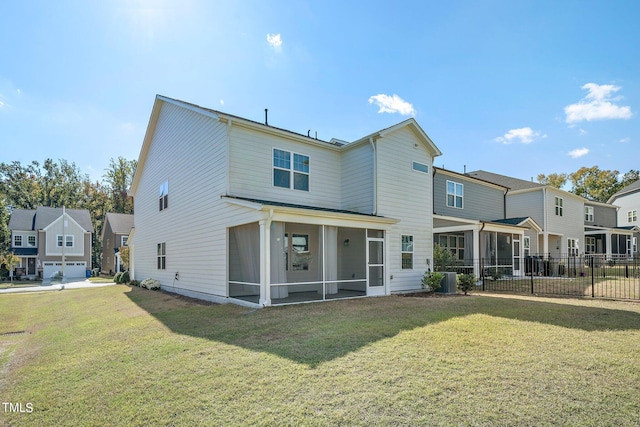 back of property with a garage, a sunroom, and a lawn