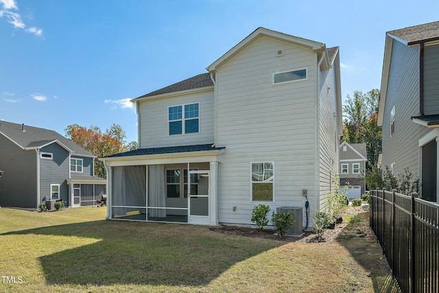 rear view of property featuring cooling unit, a yard, and a sunroom