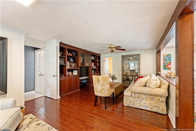 living room with ornamental molding, ceiling fan, dark hardwood / wood-style floors, and a textured ceiling