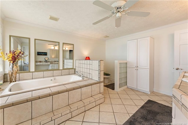 bathroom featuring a relaxing tiled tub, crown molding, a textured ceiling, and tile patterned floors