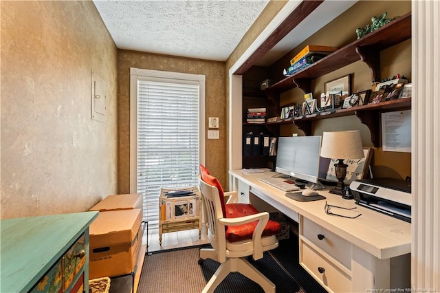 home office with a textured ceiling, built in desk, and electric panel