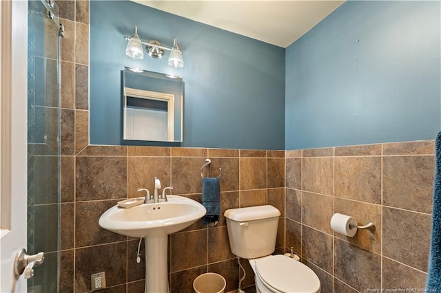 bathroom featuring tile walls and toilet