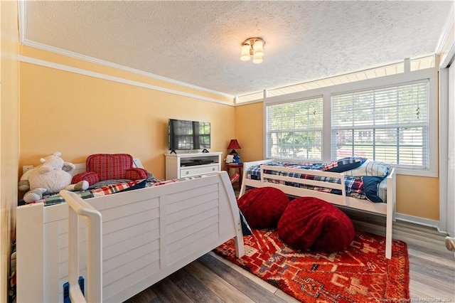 bedroom featuring a textured ceiling, crown molding, and hardwood / wood-style floors