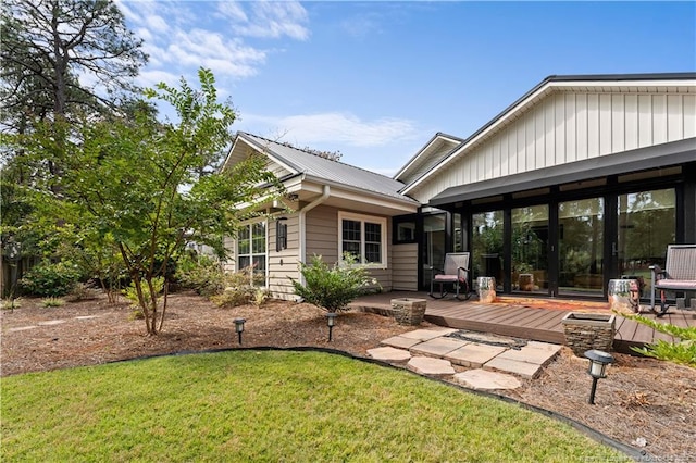 rear view of property featuring a yard and a deck