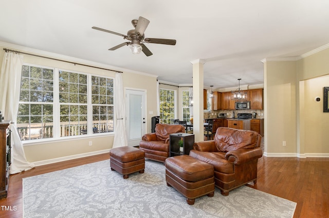 living room with crown molding, light hardwood / wood-style flooring, ornate columns, and ceiling fan