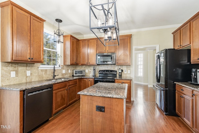 kitchen with black appliances, a wealth of natural light, pendant lighting, and a kitchen island