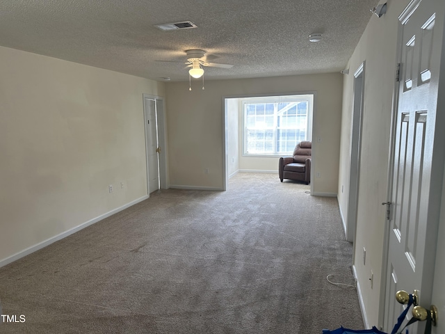 spare room with ceiling fan, a textured ceiling, and carpet floors