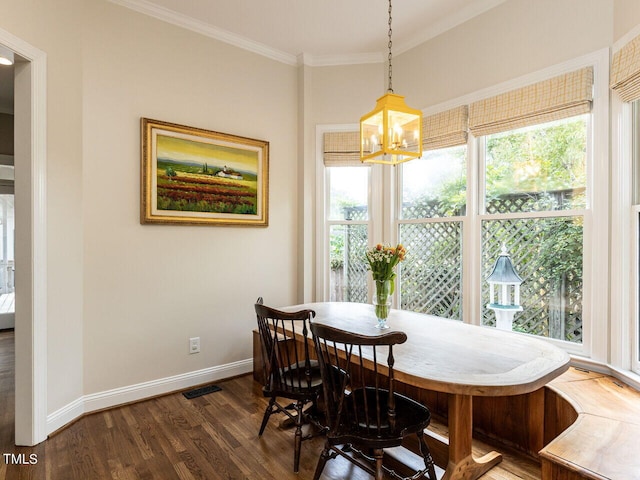 dining space with dark hardwood / wood-style floors, plenty of natural light, and crown molding