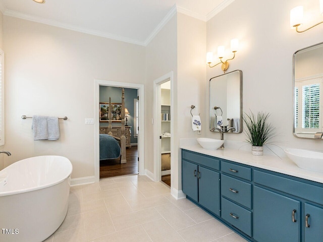 bathroom with tile patterned flooring, a bath, vanity, and ornamental molding