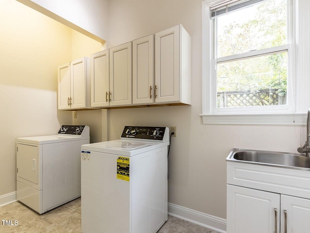 laundry room with cabinets, separate washer and dryer, sink, and a wealth of natural light