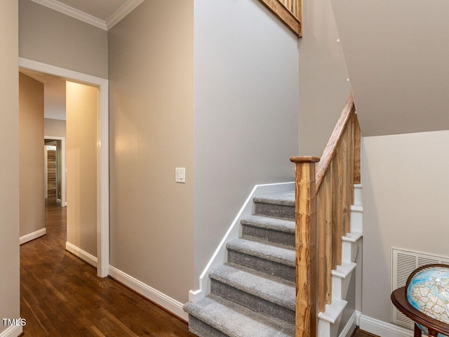 staircase with hardwood / wood-style floors and crown molding