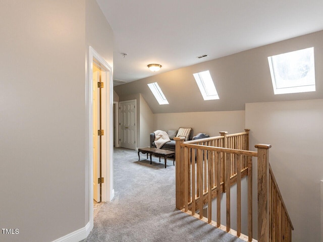 hall featuring carpet flooring and vaulted ceiling