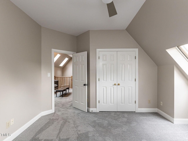 bonus room featuring lofted ceiling with skylight, ceiling fan, and light colored carpet