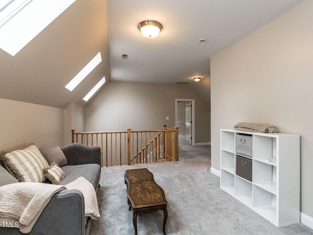 living area with vaulted ceiling with skylight and carpet