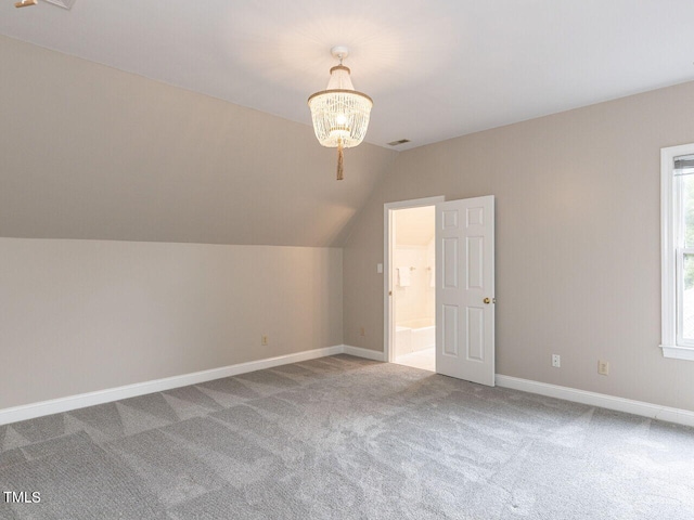 additional living space with carpet, lofted ceiling, and a notable chandelier