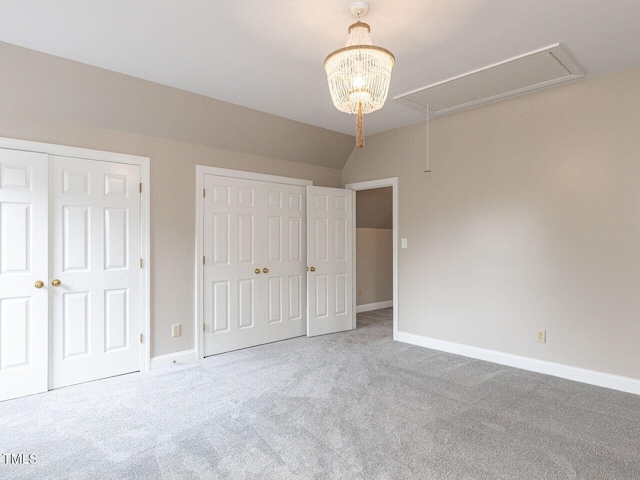 unfurnished bedroom with vaulted ceiling, carpet floors, and two closets