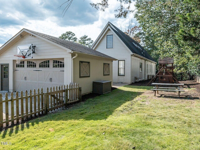 back of house with a lawn, an outbuilding, and a garage