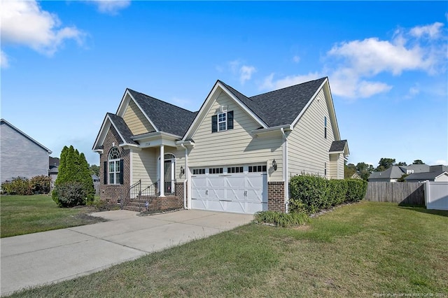 view of front facade with a garage, a front yard, brick siding, and fence