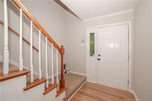 entrance foyer featuring crown molding and light hardwood / wood-style flooring