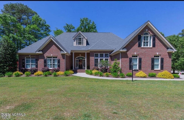 view of front of home with brick siding and a front lawn