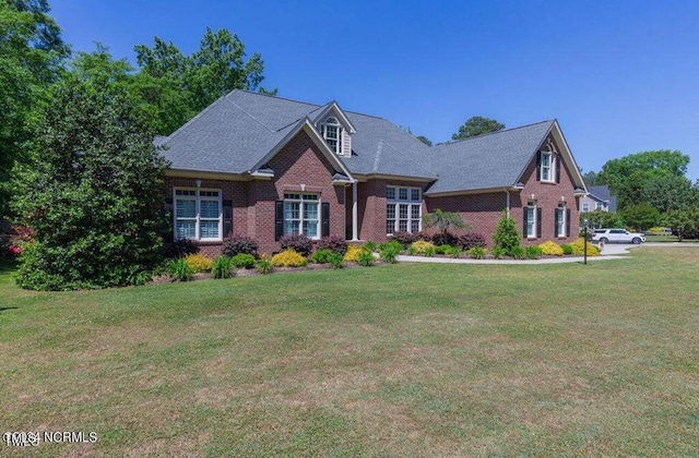 view of front facade featuring brick siding and a front yard