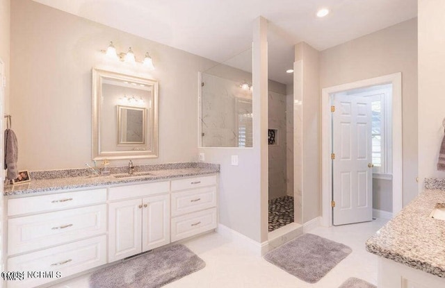 full bath with a shower stall, vanity, baseboards, and recessed lighting