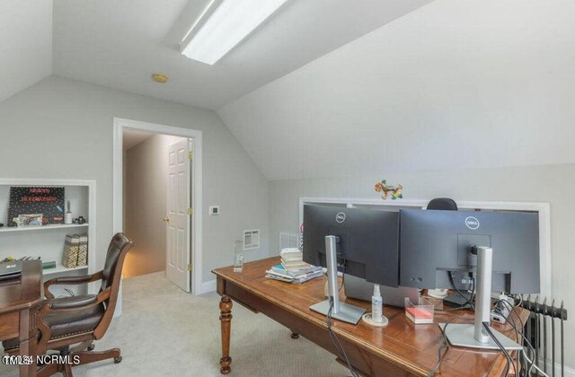 carpeted office space featuring vaulted ceiling