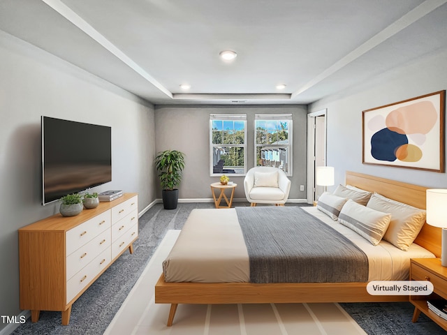 bedroom featuring light carpet and a tray ceiling