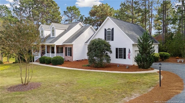 cape cod home featuring a front yard