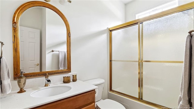 full bathroom with vanity, toilet, and combined bath / shower with glass door