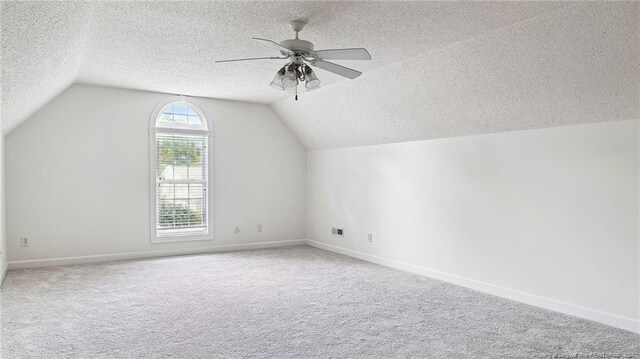 bonus room featuring lofted ceiling, a textured ceiling, and carpet flooring