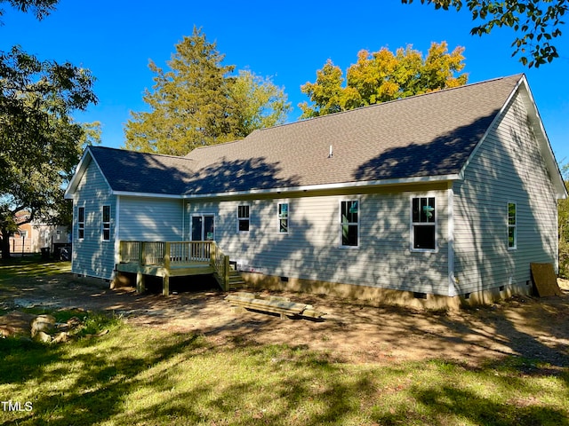 rear view of property with a wooden deck and a yard