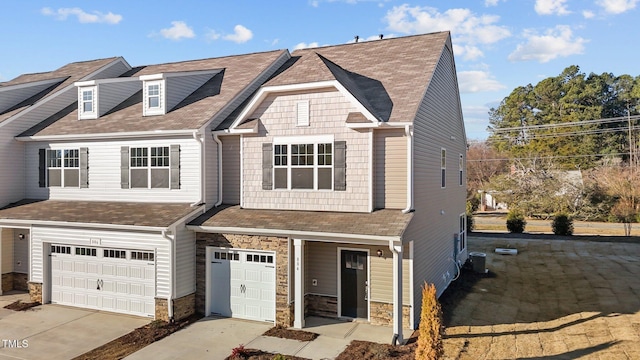 view of front of house with a garage and central air condition unit