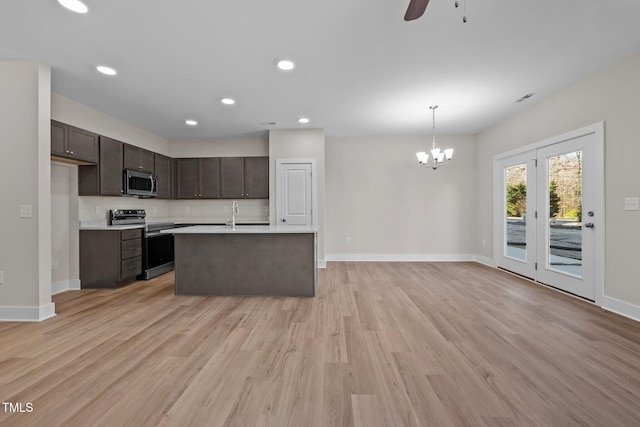 kitchen featuring dark brown cabinetry, stainless steel appliances, pendant lighting, ceiling fan with notable chandelier, and light wood-type flooring