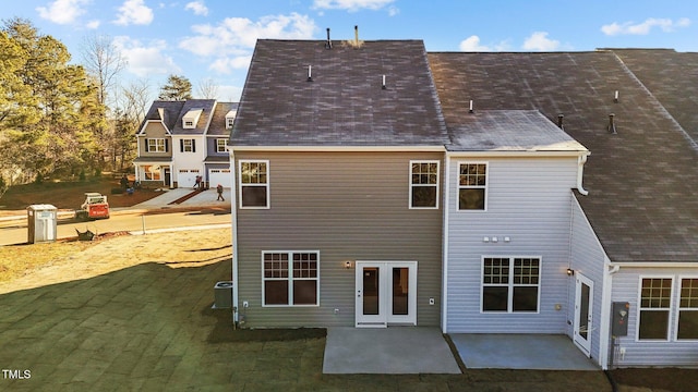 rear view of property with a patio area, a yard, and central AC