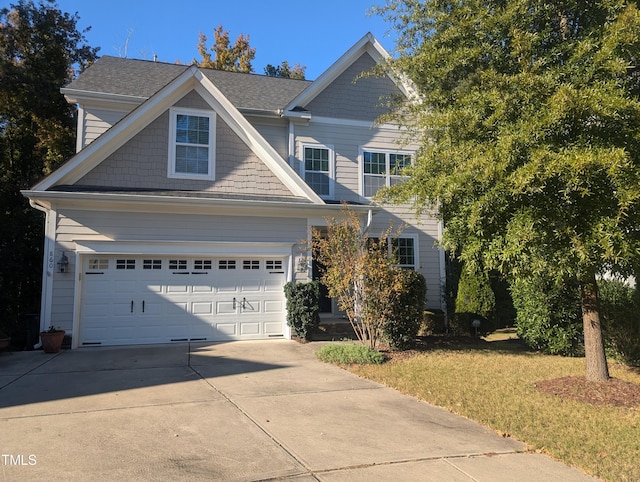 craftsman-style home featuring a front lawn and a garage