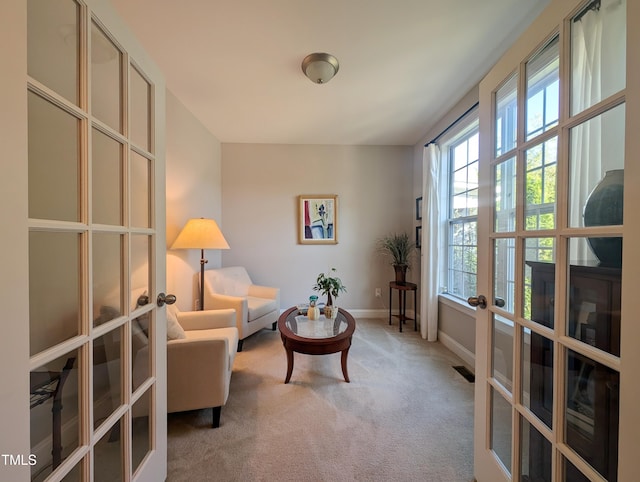 living area featuring french doors and light carpet