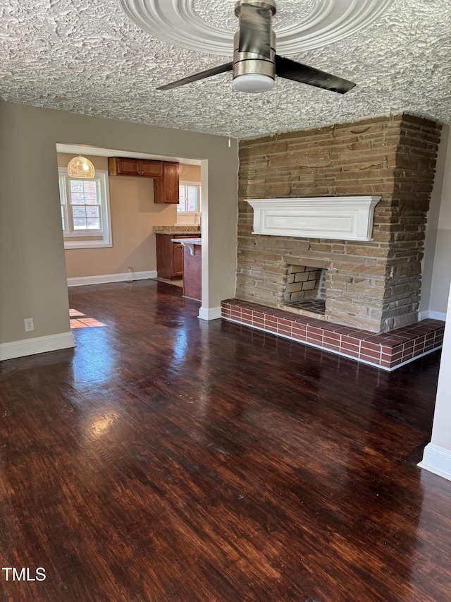 405 Whitfield Dr, Goldsboro, NC 27530 - unfurnished living room with a ceiling fan, baseboards, a glass covered fireplace, and dark wood-type flooring