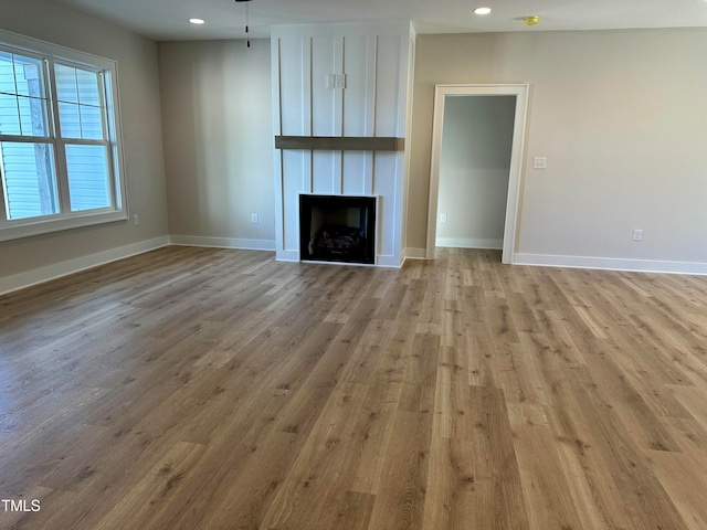 unfurnished living room featuring a fireplace and light hardwood / wood-style flooring