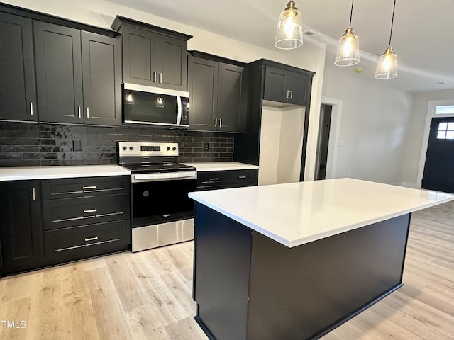 kitchen with a center island, hanging light fixtures, stainless steel appliances, backsplash, and light hardwood / wood-style floors