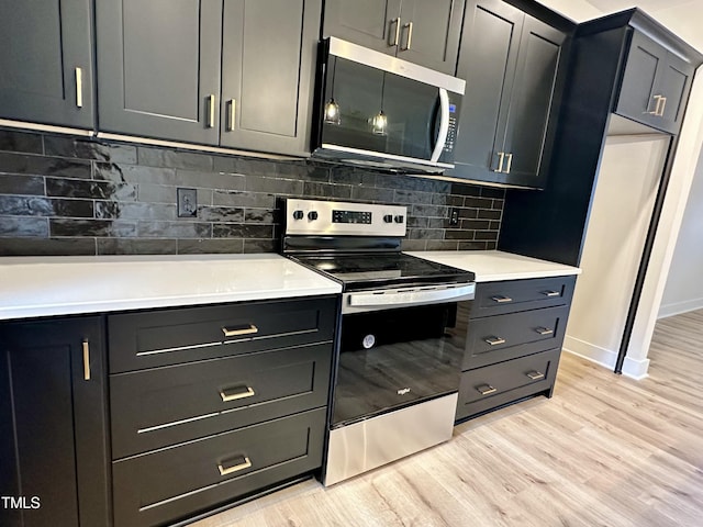 kitchen featuring backsplash, light hardwood / wood-style flooring, and appliances with stainless steel finishes