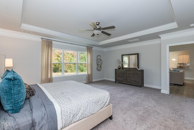 bedroom with ceiling fan, a raised ceiling, crown molding, and light colored carpet