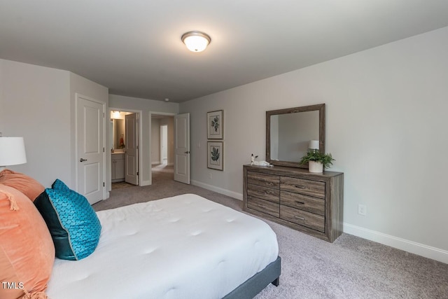 bedroom with connected bathroom and light carpet