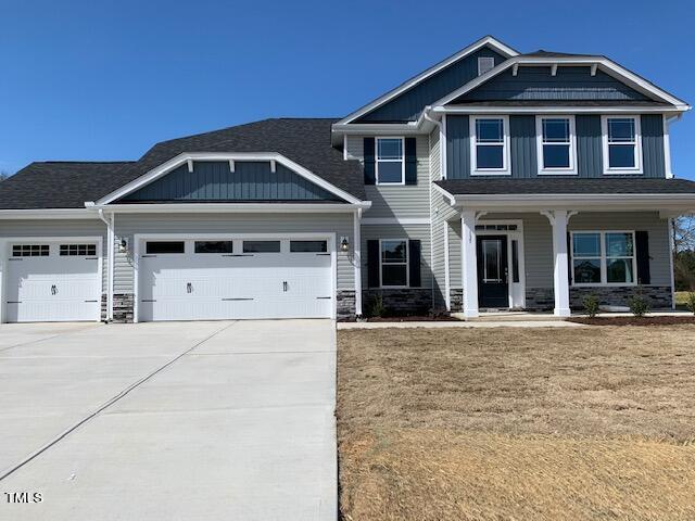 craftsman-style house with a garage, covered porch, and a front yard