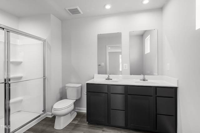 bathroom featuring vanity, toilet, hardwood / wood-style flooring, and a shower with shower door