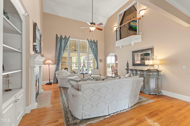 living room featuring high vaulted ceiling, light wood-type flooring, and ceiling fan