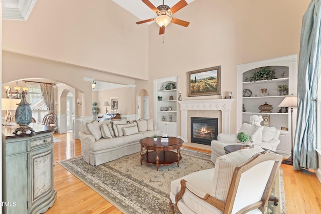 living room with light hardwood / wood-style flooring, built in features, and ceiling fan