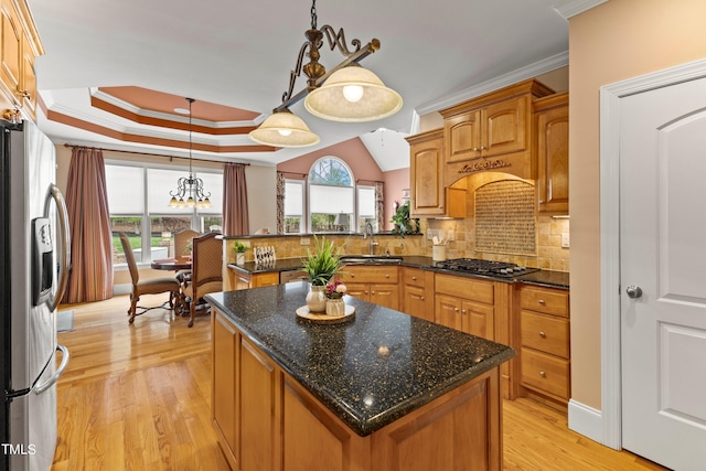 kitchen featuring light hardwood / wood-style flooring, hanging light fixtures, backsplash, a center island, and appliances with stainless steel finishes