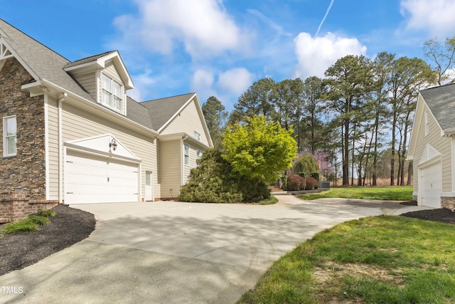 view of side of home with a yard and a garage