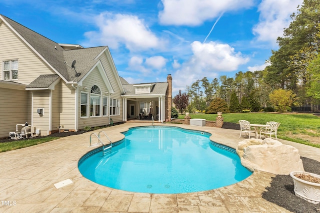 view of swimming pool featuring a patio area and a lawn